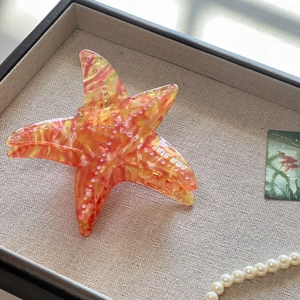 Pinza per capelli a forma di stella marina in acetato con motivo marmorizzato arancione e scritte