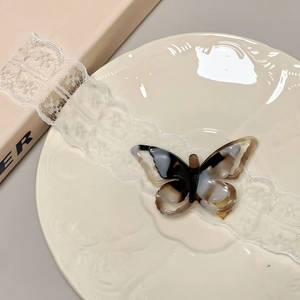 Close-up of hollow butterfly acetate hair clip with elegant marble pattern and gold metal clip