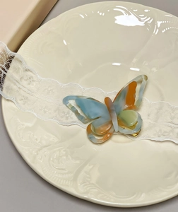 Detailed top view of 3D butterfly acetate hair clip with blue and orange marble texture