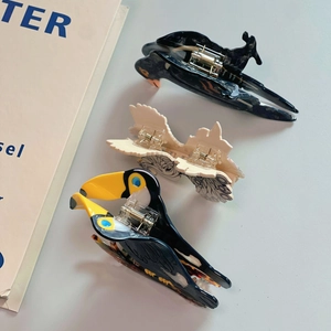 Detail von kreativen Haarklammern in Vogelform aus Acetat mit hochwertiger Textur und Feder