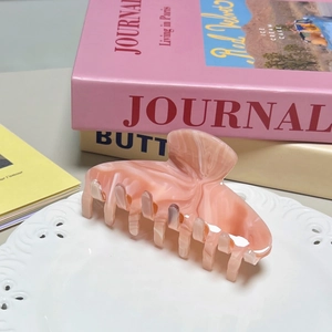Pink marble acetate hair claw clip for elegant women styling with polished shell texture