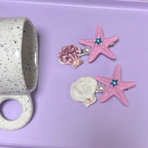 Détail de pinces à cheveux thème océan avec étoiles de mer roses, coquillages et perles