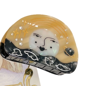 Elegant sun and moon acetate hair claw clip with star patterns and sparkling rhinestones