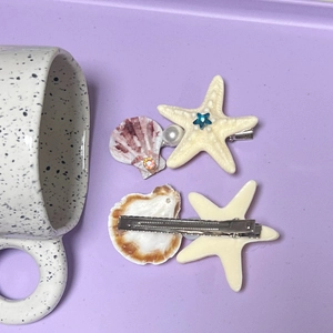 Vue détaillée des barrettes étoile de mer et coquillage avec clips métalliques à bec