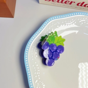 Grape shaped hair claw clip with purple resin beads and green leaf on white background