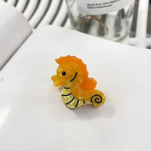 Barrette hippocampe jaune en acétate avec nageoires orange et finition brillante élégante