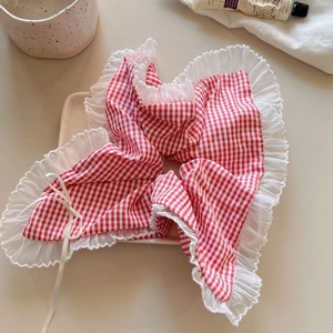 Detail of red and white checkered hair scrunchie with delicate lace edges and white ties