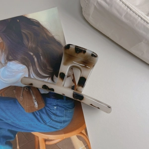 Elegant tortoiseshell hair claw clip in beige and brown acetate with a glossy finish