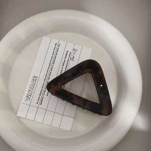 Minimalist triangle tortoise shell hair claw clip on vintage card and white plate