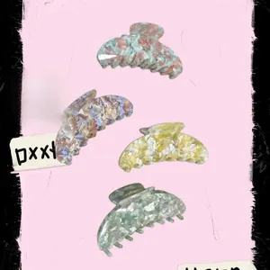 Détails de quatre pinces à cheveux en acétate aux motifs marbrés et couleurs pastel
