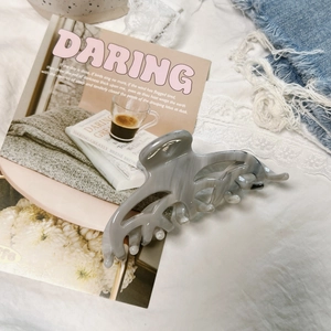 Detail of marble gray hair claw clip with acetate texture on a lace lifestyle background