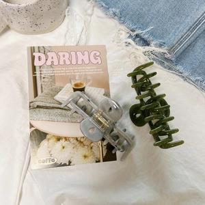 Detailed view of large marble texture and translucent resin hair claw clips on white fabric