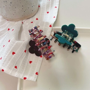 Detail view of purple and green acetate flower hair claws with colorful block patterns