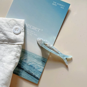 Dettaglio della molletta per capelli a forma di pesce blu con logo Sunshine Handmade