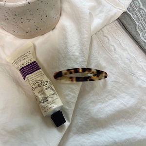 French retro scene with Roopy hand cream tube and a tortoiseshell oval hair clip