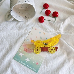 Creative cartoon banana shark hair clip with wheels shown on white fabric background