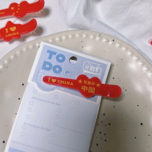 Detailed view of red patriotic hair clips with heart design and Chinese flag elements