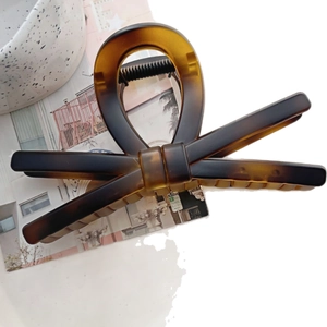 Classic amber tortoiseshell resin claw clip with elegant bow-knot design for hair styling