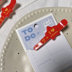 Detailed close-up of red acrylic hair clip with I Love China text and gold star pattern