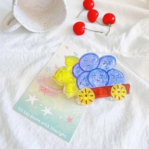 Detailed view of creative acrylic shark hair clip featuring a cartoon blue fruit cart design
