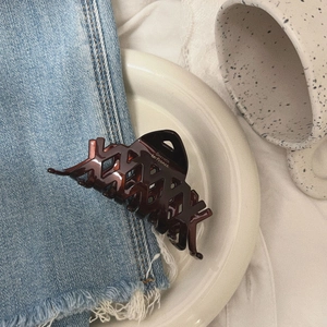 Elegant tortoiseshell claw clip with phoenix texture on denim and cream plate