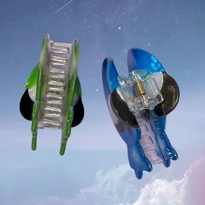 Pinze per capelli a forma di alieno e personaggio blu con sfondo di cielo stellato