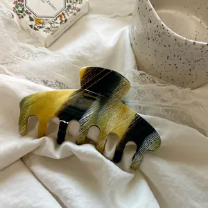 Elegant 10.5cm acetate hair claw with marble texture on soft white fabric background
