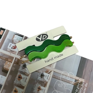 Elegant wavy acetic acid hair clips in dark and emerald green with gold emblems