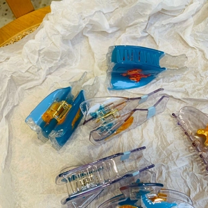 Detailed view of ocean series acetate hair claws with starfish and seashell patterns