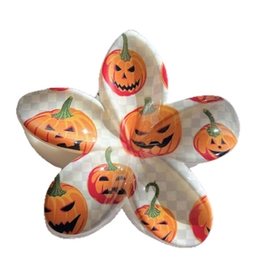Halloween plumeria hair claw with orange pumpkin face patterns and checkered design
