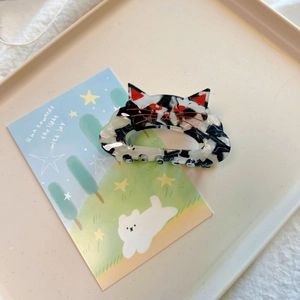 Pince à cheveux mignonne chat noir et blanc en acétate sur une carte de présentation