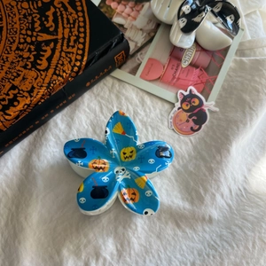 Détail de la pince à cheveux fleur bleue avec motifs citrouille et crâne d'Halloween