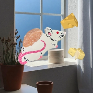 Cute white mouse hair claw clip with marble texture and pink tail on sunny window
