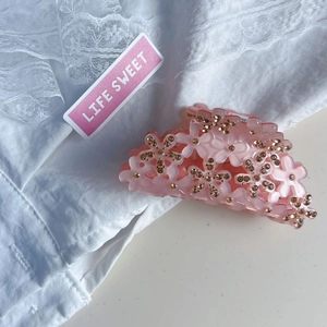 Pince à cheveux fleur rose en acrylique avec strass et ressort doré élégant
