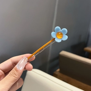Pince à cheveux fleur en résine bleu clair avec perle ambrée sur base en métal jaune