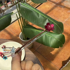 Détail de la pince à cheveux fleur en acide acétique avec pétales lisses et ressort argent