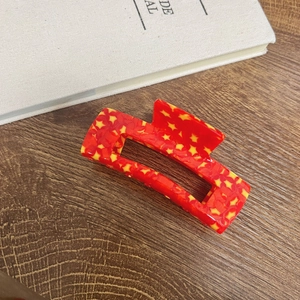 Red acetate claw clip with yellow star patterns for women's high ponytail hairstyles