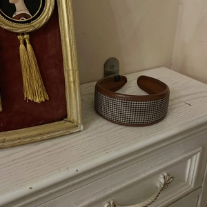 Französisches Vintage-Haarband mit Hahnentrittmuster und Lederbesatz auf weißer Schublade