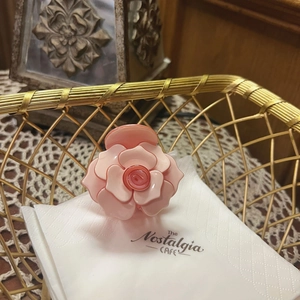Detailed view of pink rose claw clip hair accessory in a vintage golden basket