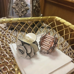 Close-up of cream white and pink camellia hair claws with black edges in a basket