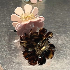 Dettaglio di fermagli per capelli floreali rosa e tartarugati con petali in acetato