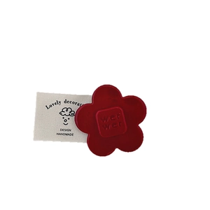 Pince à cheveux fleurie rouge mat avec gaufrage de lettres et étiquette en tissu