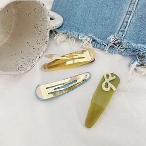 Close-up of pastel resin water-drop hair clips and olive green bow barrette set