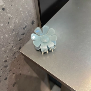 Dettaglio molletta per capelli a fiore azzurro con petali luccicanti e molla in metallo robusta