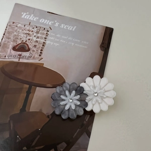 Elegant pair of daisy acetate hair clips in grey and white with rhinestone detail