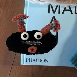 Pince à cheveux monstre en peluche noire avec cornes orange et grands yeux