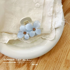 Molla per capelli a fiori in acetato azzurro con cristalli ambra su pizzo bianco