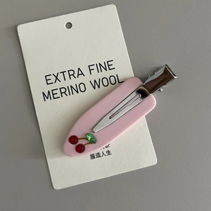 Detail of pink acetate duckbill hair clip featuring cute rhinestone cherry embellishments