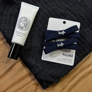 Elegant navy blue bow hair clips set with silver puppy pendant on fabric texture