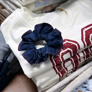 Elastico per capelli in denim blu scuro con cuciture rosse e texture a pieghe